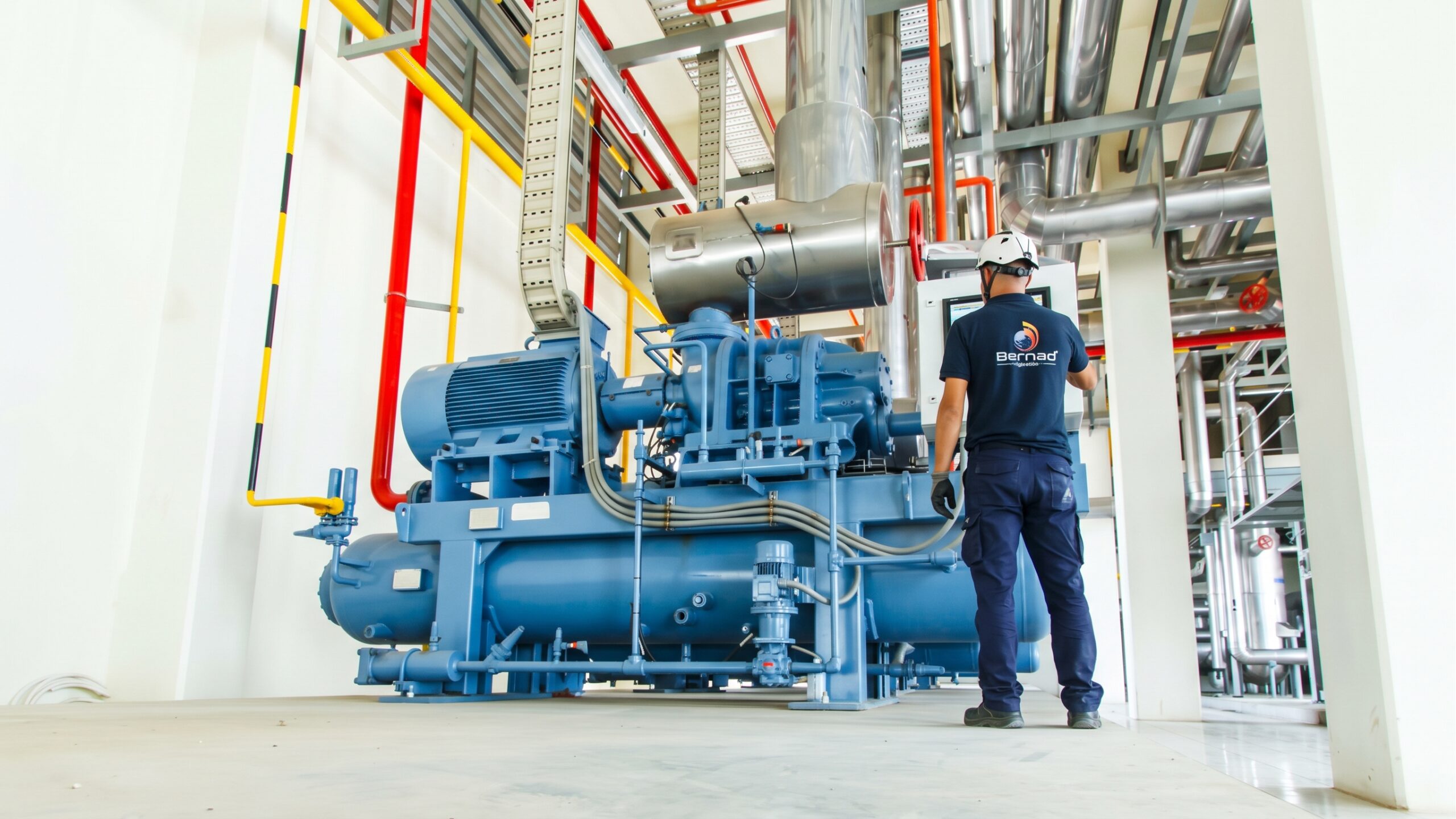 Técnico de José Bernad revisando una central frigorífica industrial azul en una sala de máquinas